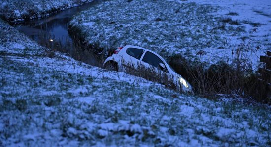 Auto in sloot na glijpartij op rotonde in Sneek