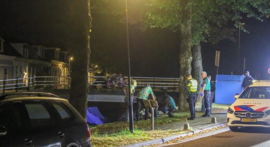 Man valt tussen steiger en boot in water in Bolsward
